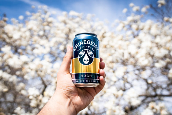 Rhinegeist Hugh Can in front of flowers