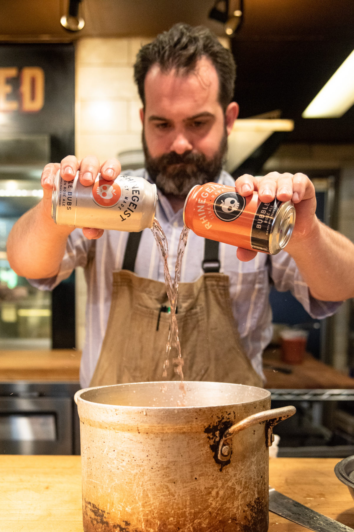 Chef pouring Rhinegeist Little Bubs and Bubbles into pot