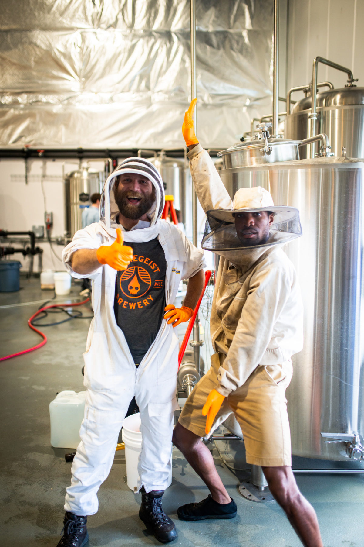 Two brewers dressed like bee keepers