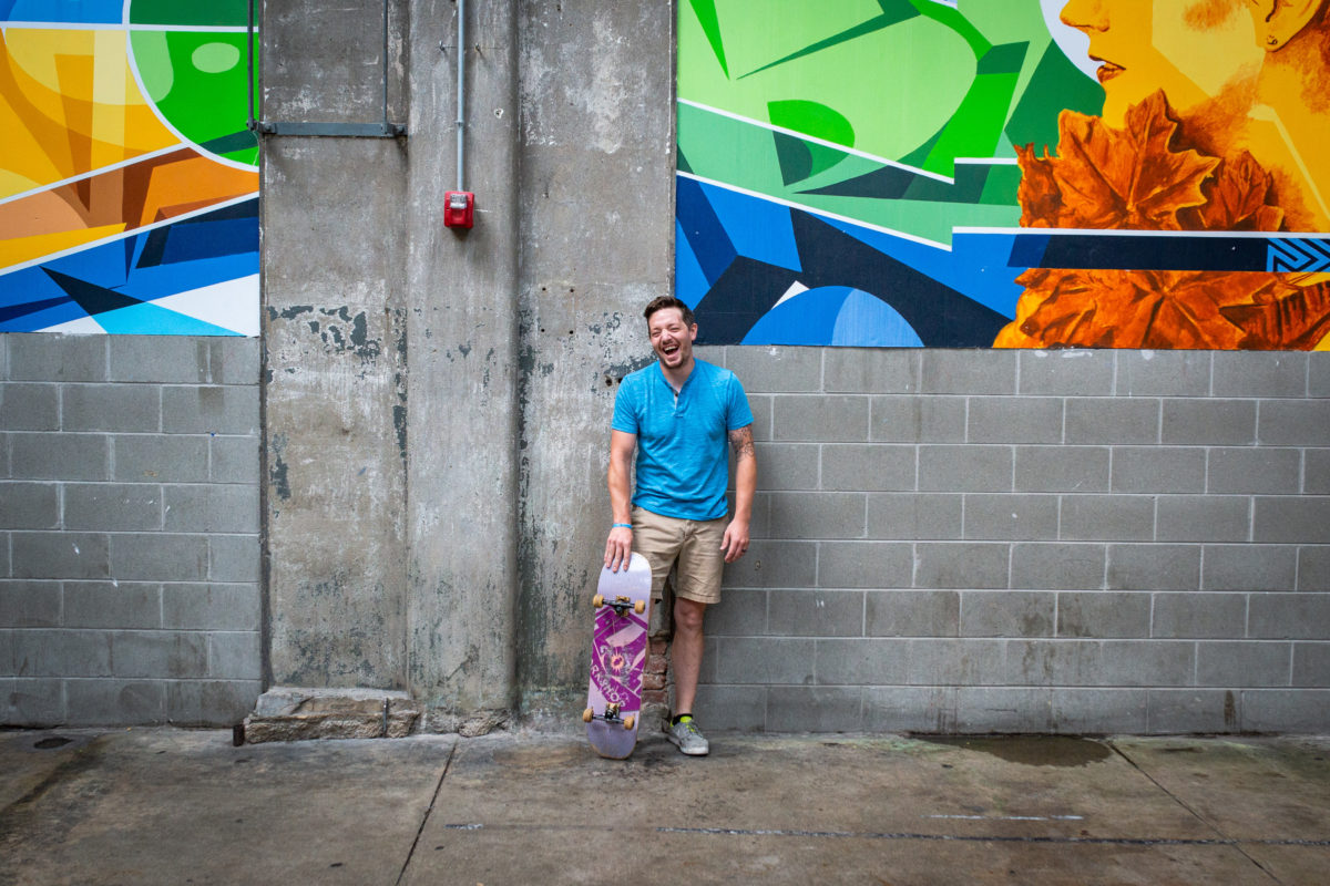 man holding skateboard in rhinegeist taproom