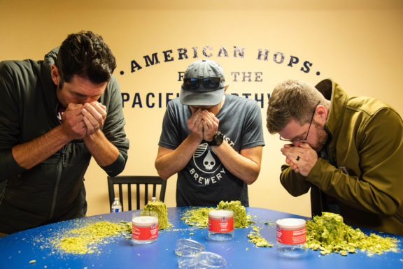 3 men sniffing hops