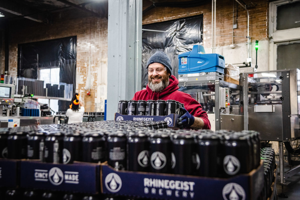 smiling man stacking beer cases