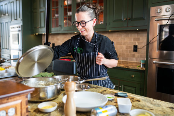 Chef lifting lid of sauce pan