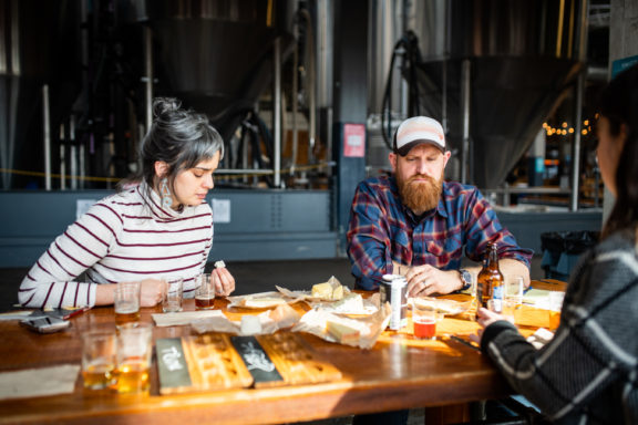 man and woman trying cheese and beer